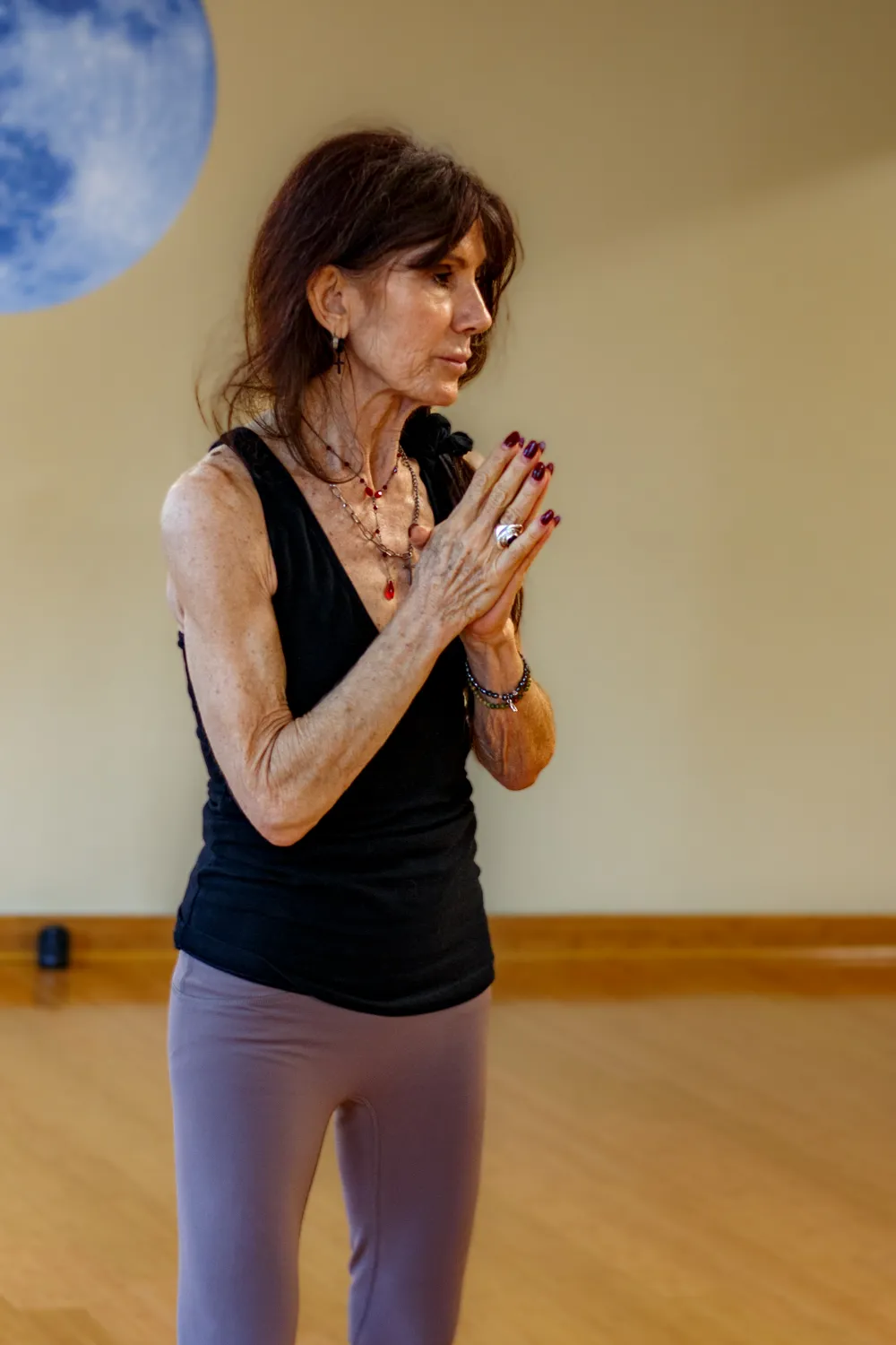 Claudia standing with hands in prayer